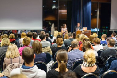 Konferans salonunda iş konferansına katılan seyirciler.