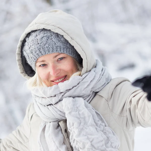 Meisje spelen met sneeuw in de winter. — Stockfoto