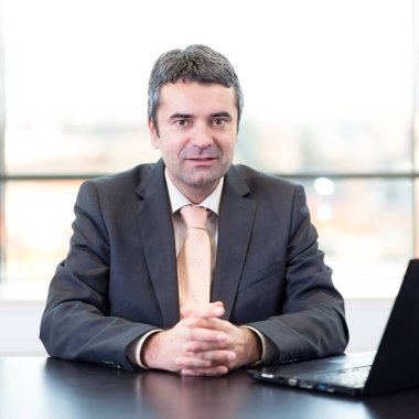 Ofis dizüstü bilgisayar ile üst düzey işadamı portresi.