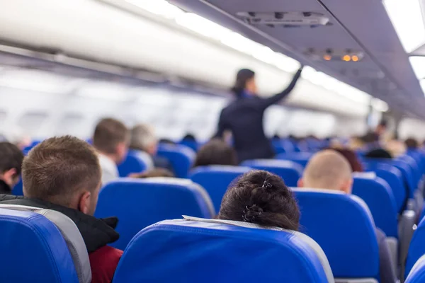 Stewardess lopen het gangpad van commerciële vliegtuig. — Stockfoto