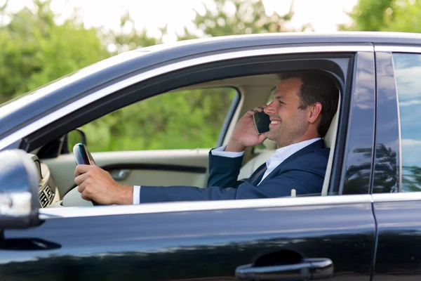 Człowiek za pomocą telefonów komórkowych podczas jazdy. — Zdjęcie stockowe