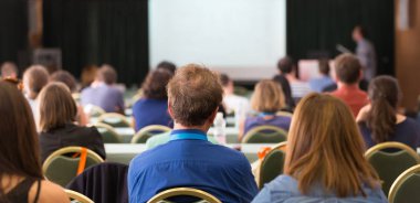 Konferans salonunda iş konferansına katılan seyirciler.