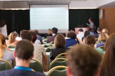 Konferans salonunda iş konferansına katılan seyirciler.