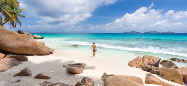 Uomo godendo Anse Patates foto spiaggia perfetta sull'isola di La Digue, Seychelles . — Foto Stock