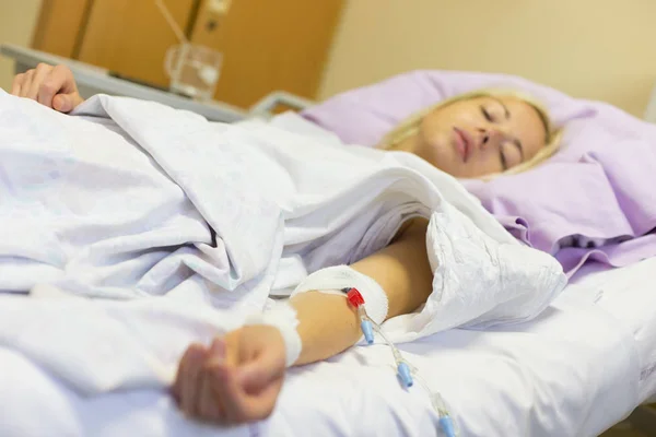 Paciente mujer postrada en cama recuperándose después de la cirugía en atención hospitalaria . —  Fotos de Stock