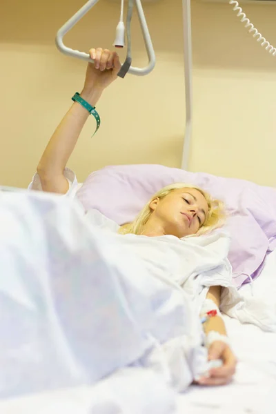 Upoutaný na lůžko pacientka zotavuje po operaci v nemocniční péči. — Stock fotografie