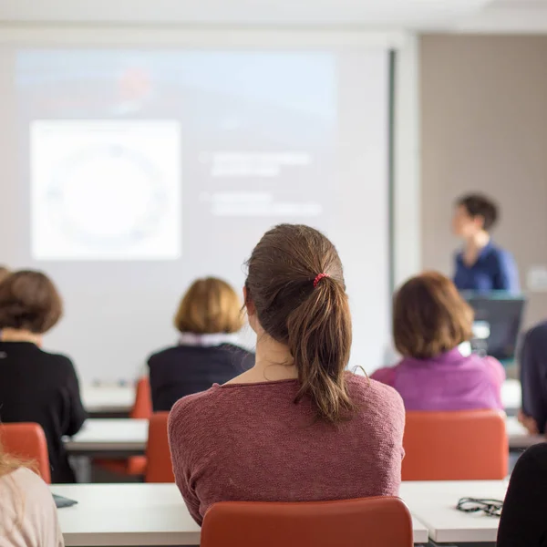 Kvinnan ger presentation i föreläsningssalen vid universitetet. — Stockfoto