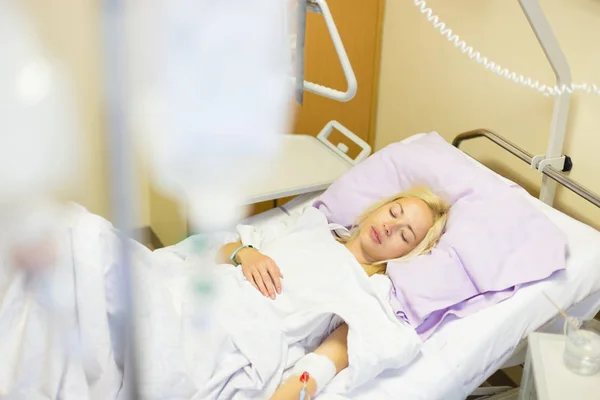 Paciente mujer postrada en cama recuperándose después de la cirugía en atención hospitalaria . —  Fotos de Stock