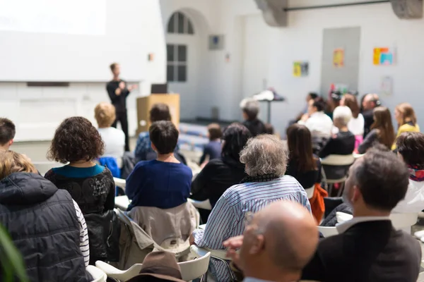 Üniversitedeki konferans salonunda sunum yapan kadın..