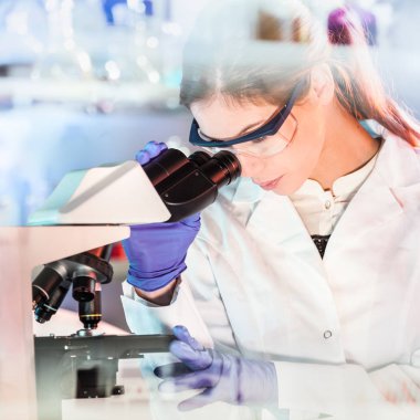 Yaşam bilimi araştırmacısı genetik bilim laboratuvarında mikroskop yapıyor..