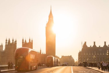 Trafik ve günbatımı, Londra, İngiltere'de Westminster Köprüsü'nde insanları rasgele.