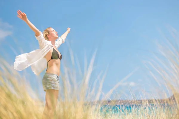 Kostenlose glückliche Frau genießt Sonne im Urlaub. — Stockfoto