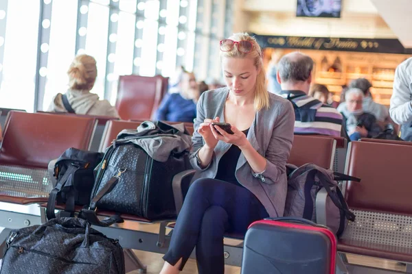 Női utas használ sejt telefon, miközben várja a repülőtér. — Stock Fotó