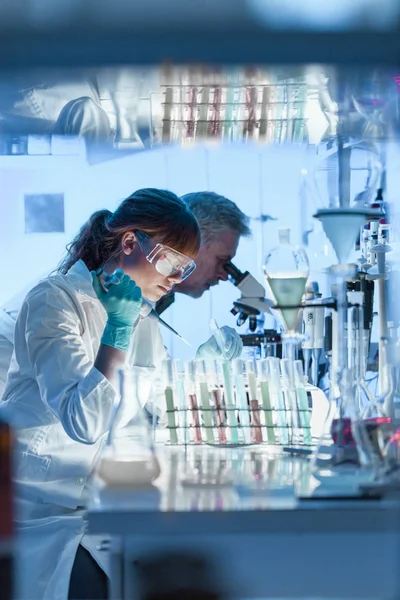 Investigadores sanitarios que trabajan en laboratorio científico. — Foto de Stock