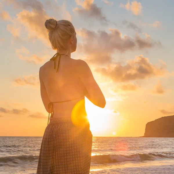 Vrouw oefenen yoga op zee strand bij zonsondergang. — Stockfoto