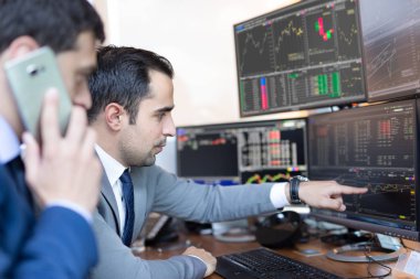 Borsacılar bilgisayar ekranlarına bakıyor, çevrimiçi ticaret yapıyorlar..
