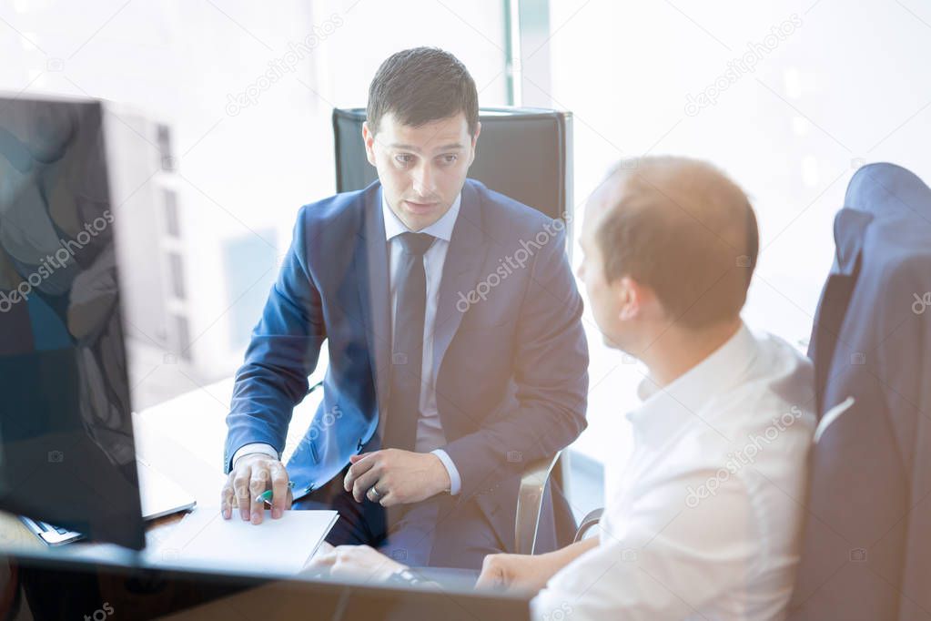 Two businessmen discussing a bisiness problem at meeting in trading office.