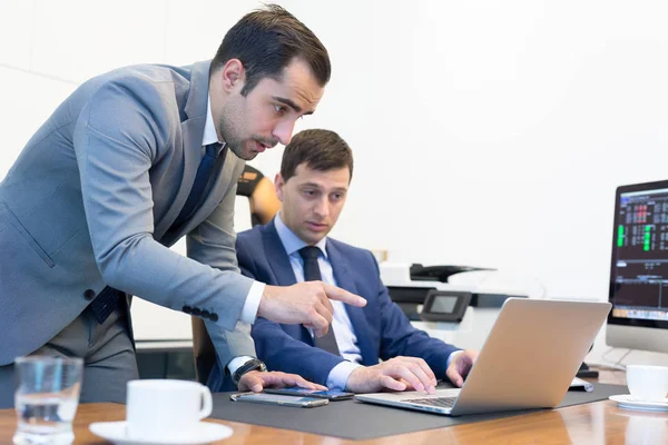 El equipo de negocios resuelve de forma remota un problema en una reunión de negocios con un ordenador portátil y un touchpad . — Foto de Stock