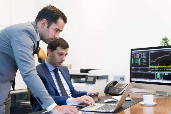 El equipo de negocios resuelve de forma remota un problema en una reunión de negocios con un ordenador portátil y un touchpad . — Foto de Stock