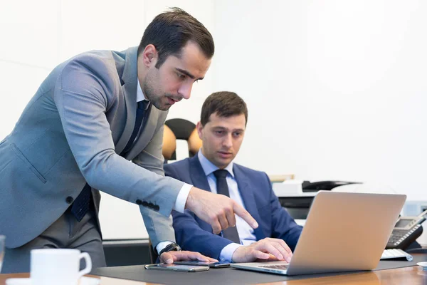 Equipe de negócios resolvendo remotamente um problema na reunião de negócios usando computador portátil e touchpad . — Fotografia de Stock