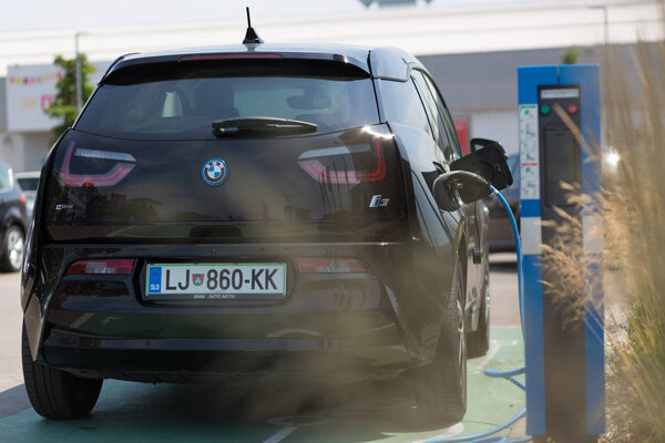 i3 BMW electric car being charged at electric car charging station.
