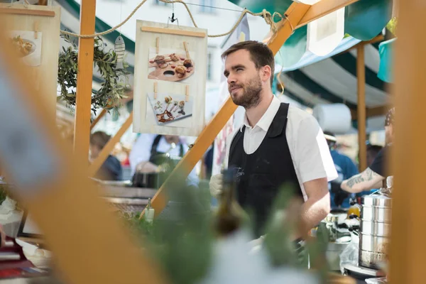 Uomo che serve cibo di strada in occasione di un evento internazionale di cucina a Lubiana, Slovenia . — Foto Stock