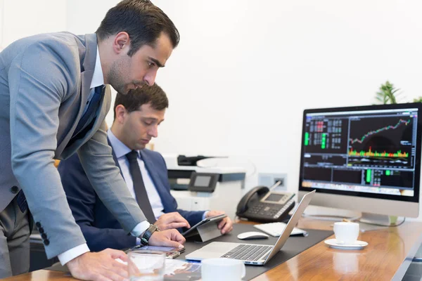 Equipe de negócios resolvendo remotamente um problema na reunião de negócios usando computador portátil e touchpad . — Fotografia de Stock