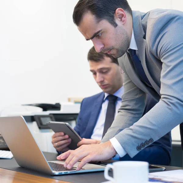 Equipe de negócios resolvendo remotamente um problema na reunião de negócios usando computador portátil e touchpad . — Fotografia de Stock