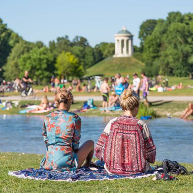 Bronzlaşma, yüzme ve Englischer Garten Münih, Almanya yaz zevk insanlar.