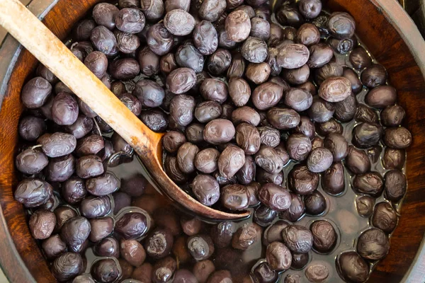 Olives in wooden bowls with serving spoon. — Stock Photo, Image