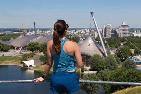 Sportovní žena užívat si výhledu přes Mnichov Olympijský park. — Stock fotografie