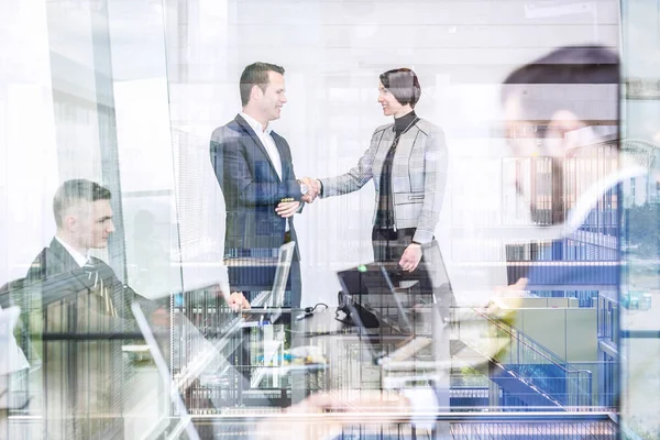 Zakenmensen schudden handen in moder corporate office. — Stockfoto