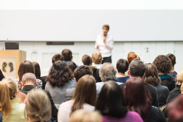 Woman giving presentation in lecture hall at university.