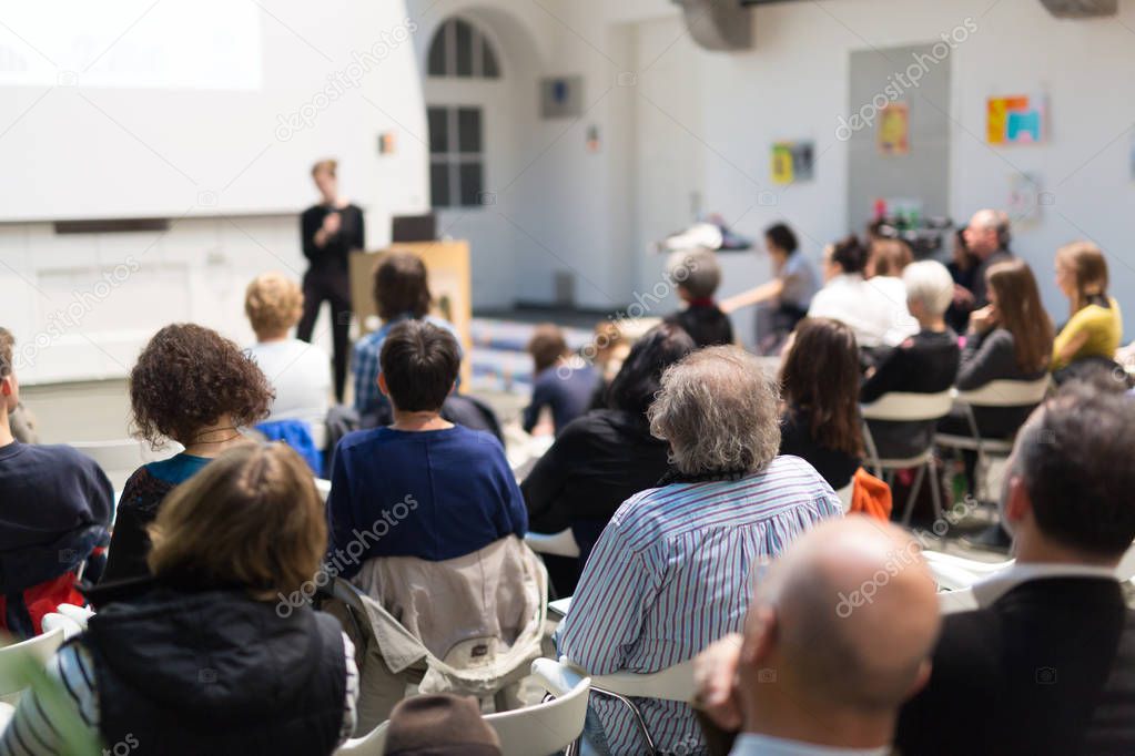 Woman giving presentation in lecture hall at university.