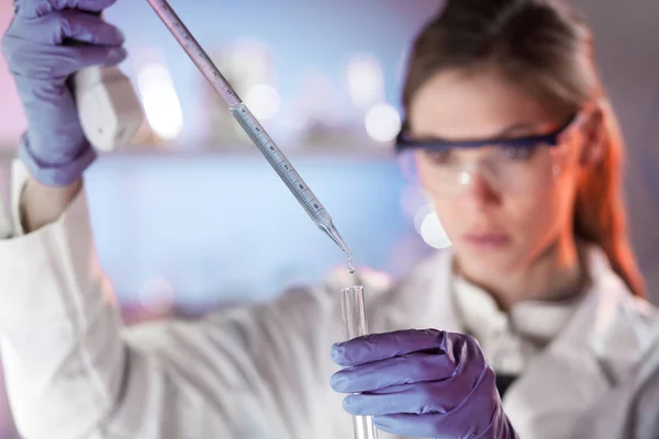 Young scientist pipetting in life science laboratory. — Stock Photo, Image