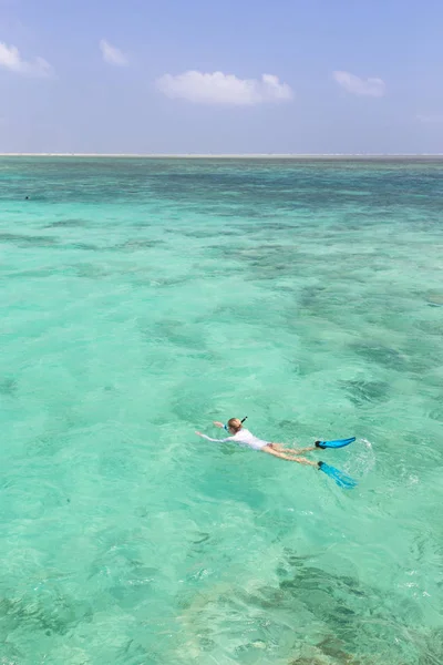 Mujer haciendo snorkel en mar claro y poco profundo de laguna tropical con agua azul turquesa. —  Fotos de Stock