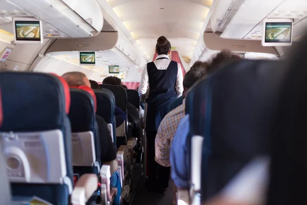 Interior del avión comercial con pasajeros en asientos durante el vuelo . — Foto de Stock