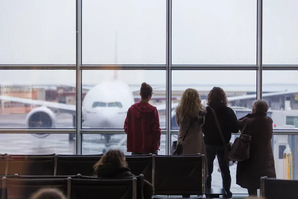 Lidé čekají na odlet letadla na deštivý den. — Stock fotografie