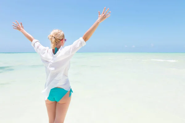 Gelukkige vrouw genieten, ontspannen vreugdevol in de zomer op tropisch strand. — Stockfoto