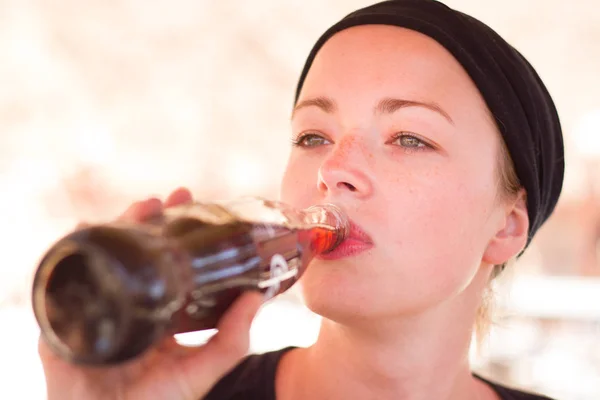 Sediento viajero femenino activo beber cola suave dring de botella de vidrio . — Foto de Stock