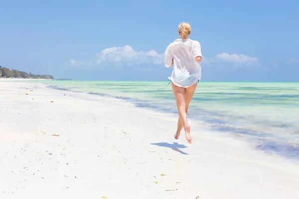 Mujer feliz divirtiéndose, disfrutando del verano, corriendo alegremente en la playa tropical . — Foto de Stock