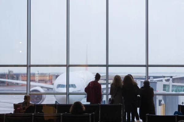 Pessoas esperando a partida do avião em um dia chuvoso . — Fotografia de Stock