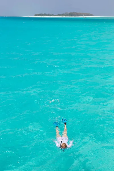 Mujer haciendo snorkel en mar claro y poco profundo de laguna tropical con agua azul turquesa. — Foto de Stock