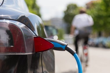 Şarj olan bir elektrikli arabaya güç kaynağı takıldı..