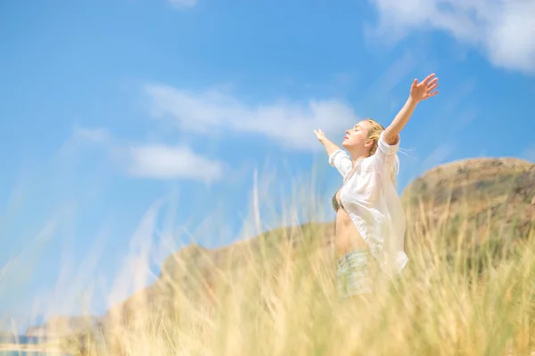 Kostenlose glückliche Frau genießt Sonne im Urlaub. — Stockfoto