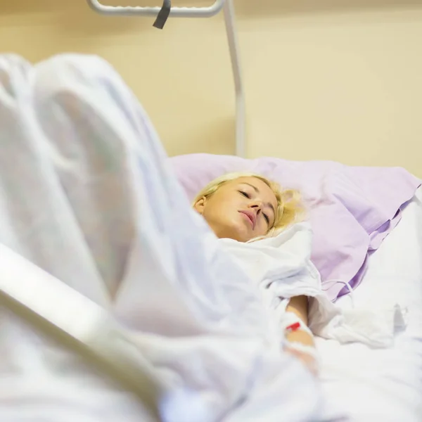 Paciente mujer postrada en cama recuperándose después de la cirugía en atención hospitalaria . —  Fotos de Stock