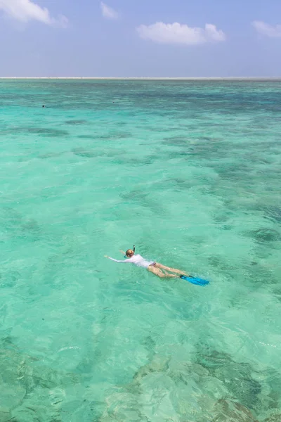 Mujer haciendo snorkel en mar claro y poco profundo de laguna tropical con agua azul turquesa. — Foto de Stock