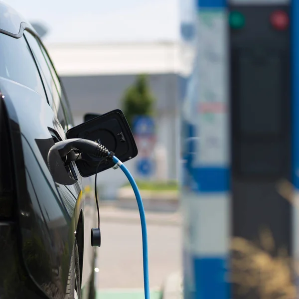 Power supply plugged into an electric car being charged. — Stock Photo, Image