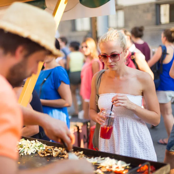 Mulher comprando refeição no festival de comida de rua . — Fotografia de Stock