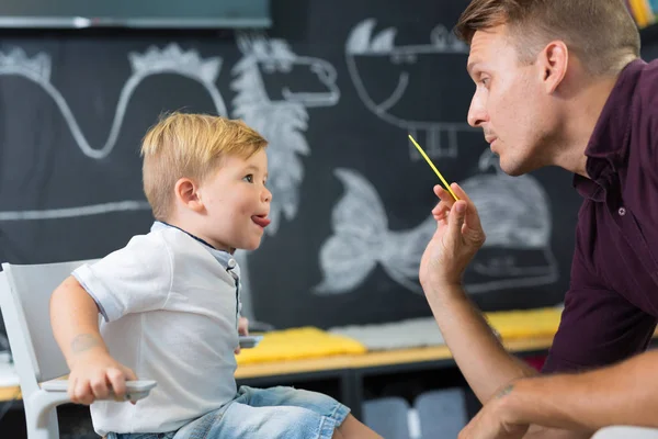 Ładny mały chłopiec o speechtherapist sesji. — Zdjęcie stockowe